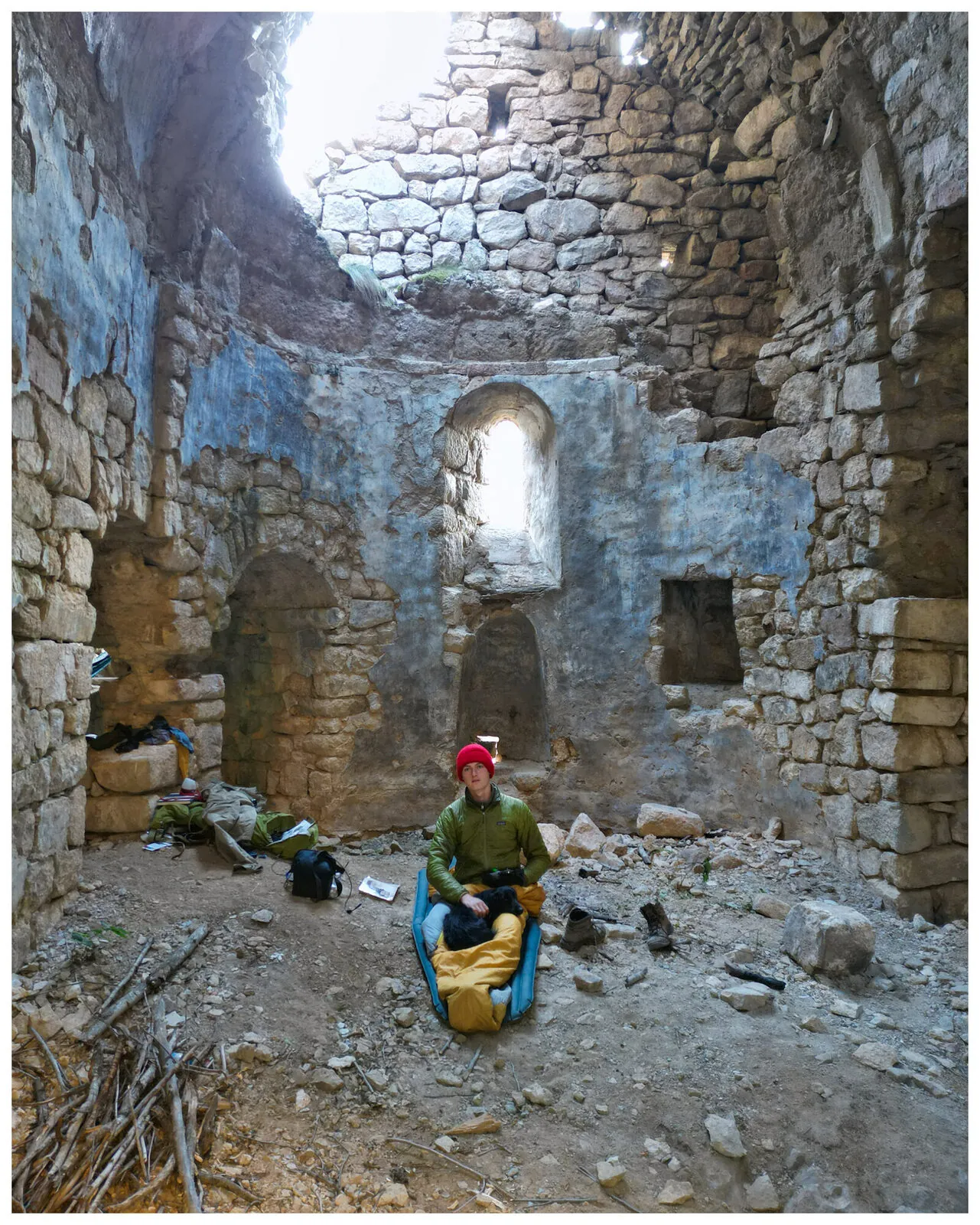 Tassilo and Fluffo, his black dog, asleep in a sleeping bag inside Nuka Sakdari, the frescoed ninth-century Georgian basilica, at dawn