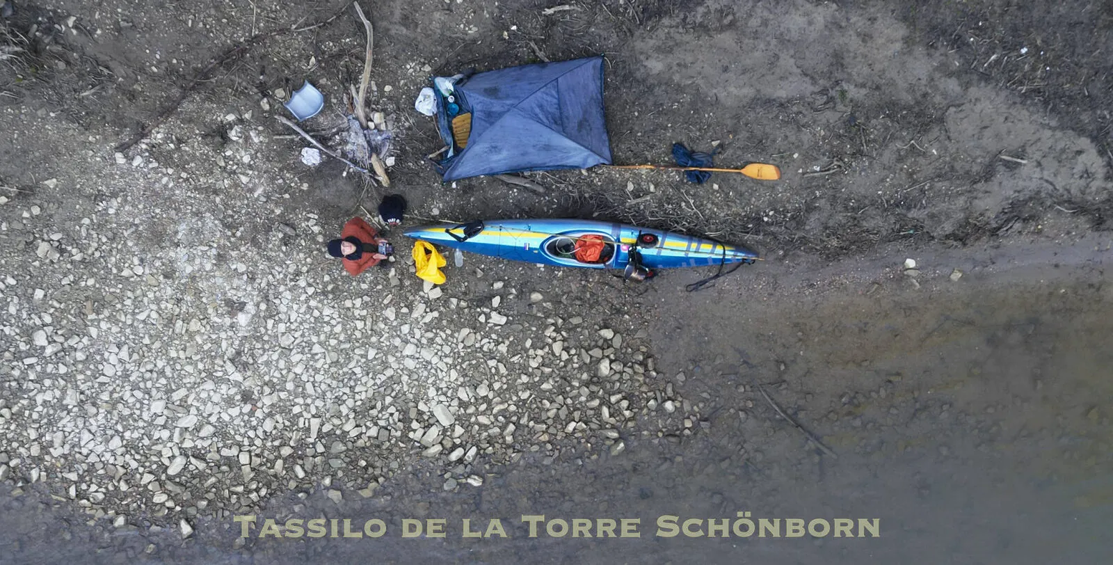 Aerial view of a bivouac on a gravel bank of the Tiber, canoe, tent and all the gear of the journey